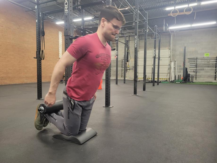 Man performing Nordic curls on the Rogue Monster Lite leg roller attachment