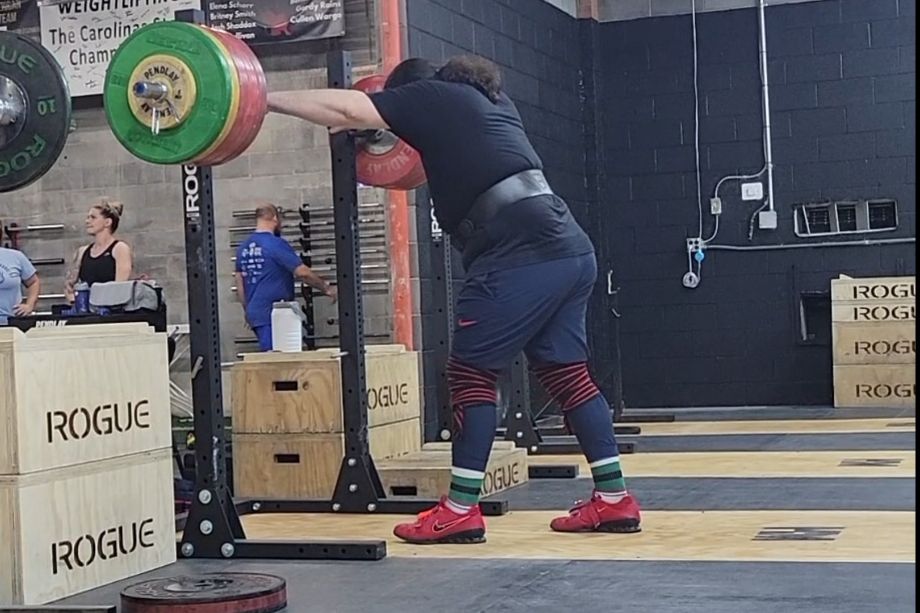 man about to squat with the rogue S1 squat stands
