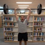 Coop doing an overhead press at a library with the Rogue Ohio Bar 2.0 S.