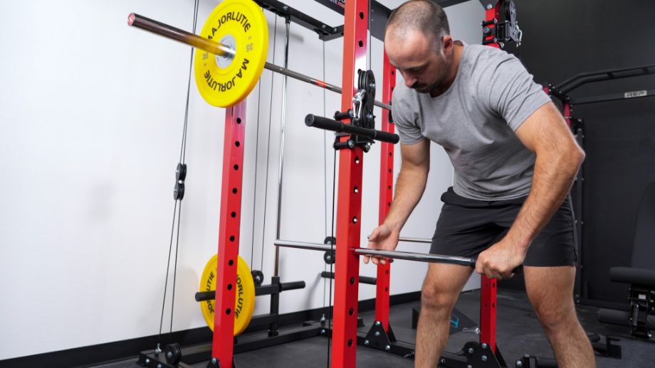 Man adjusting the safety bars of the Major Lutie Power Rack