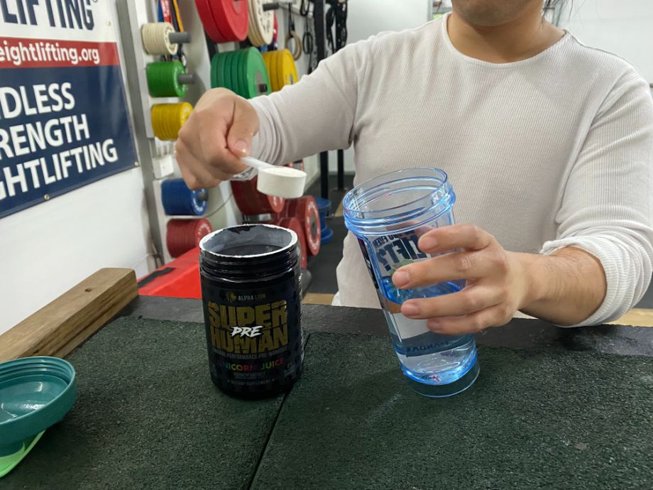 Person holding a scoop of Alpha Lion Superhuman pre-workout