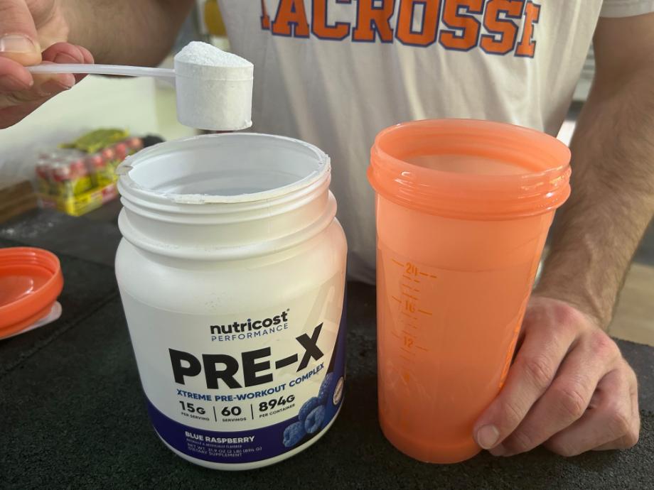 Man mixing a scoop of Nutricost Pre-X Pre-Workout in water