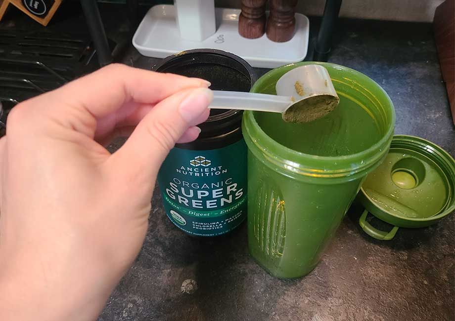 An image of Ancient Nutrition Super Greens being scooped