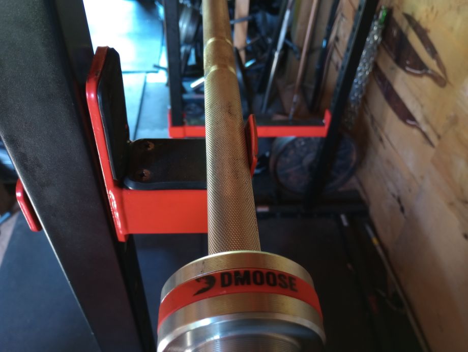 Picture of the DMoose Regional Barbell loaded in a squat rack