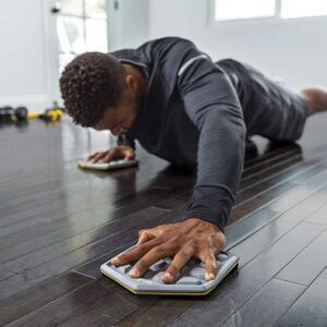 Athlete doing plank slides on exercise sliders
