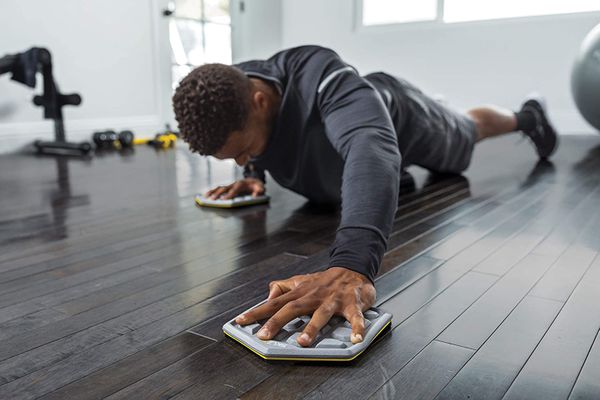 Athlete doing plank slides on exercise sliders