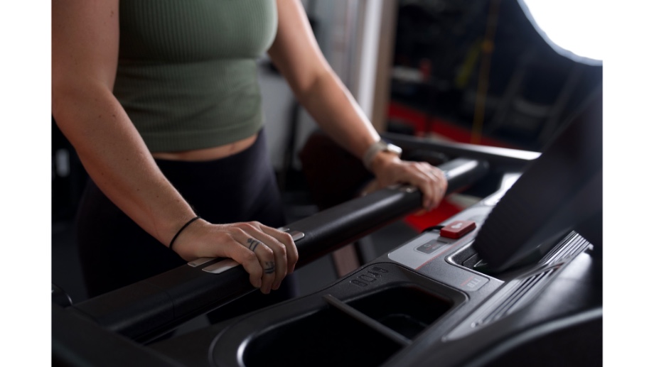 woman holding onto sole fitness tt8 treadmill handles