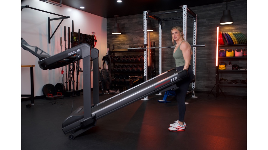 woman lifting up sole fitness tt8 treadmill to move it