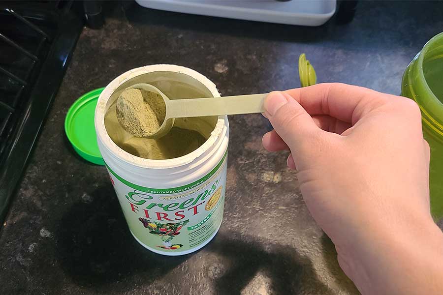 Someone Scooping Greens First Out Of The Container