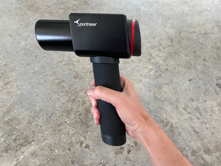 Holding the Sportneer Elite D9 massage gun