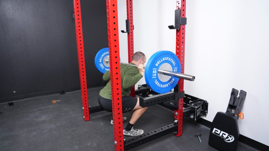 Man squatting using the PRx Profile Folding Full Cage