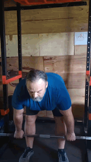 Man doing stiff-leg deadlifts in the squat rack