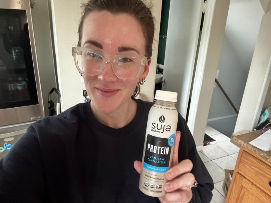 woman holding a bottle of Suja Protein Shake