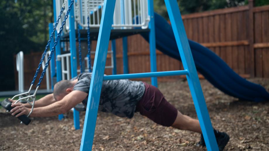 Coop does ab rollouts on the SwingSesh swing set