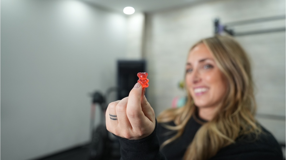 Woman holding up a Swoly Creatine gummy bear