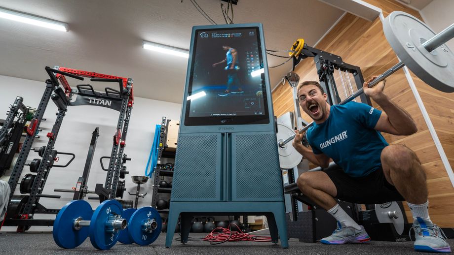 Coop doing a barbell squat next to Tempo Studio