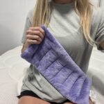 A person holds up a Suzzipad Microwaveable Heating Pad