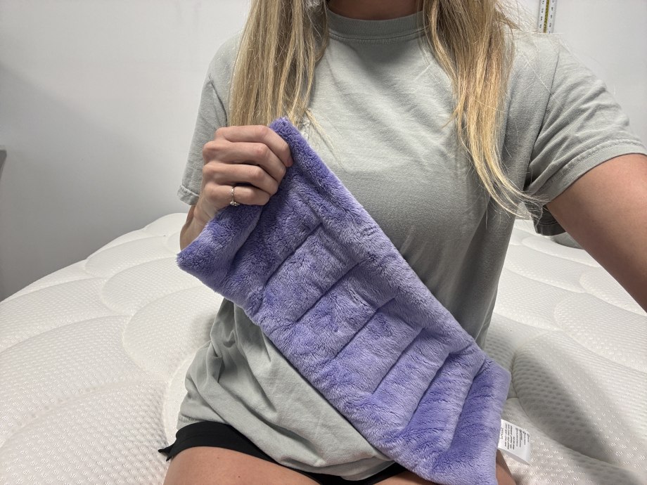 A person holds up a Suzzipad Microwaveable Heating Pad