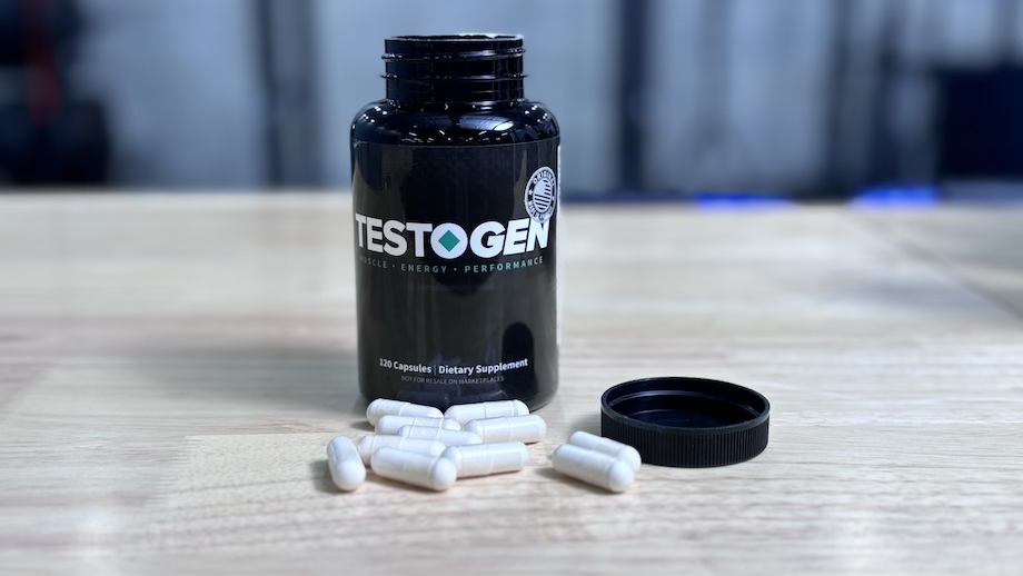 An open bottle of the Testogen supplement with some capsules .