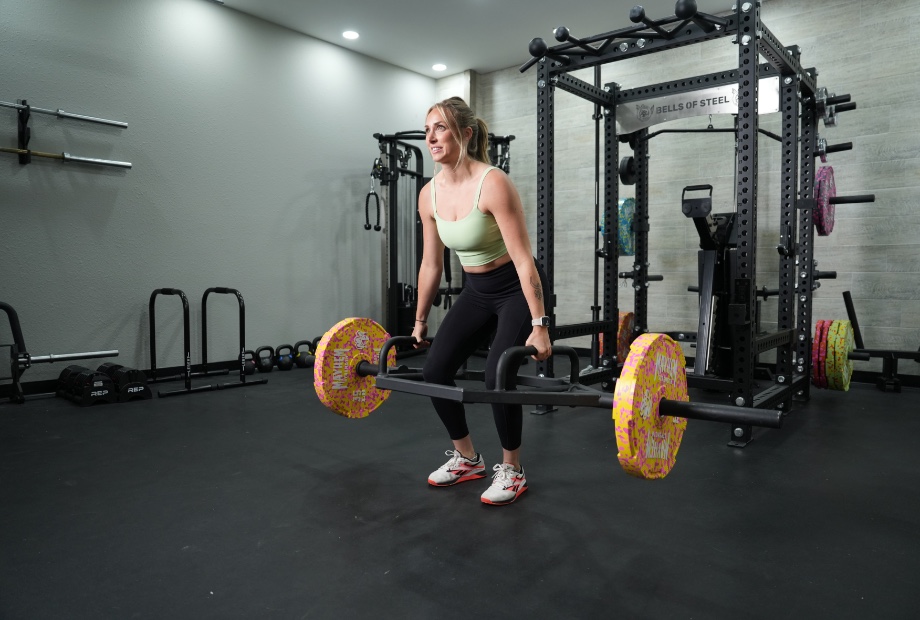A woman performs a deadlift using the Titan Fitness Rackable Hex Bar