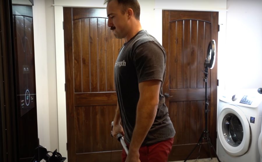 Man doing deadlifts while using the Tonal Smart Home Gym in his laundry room