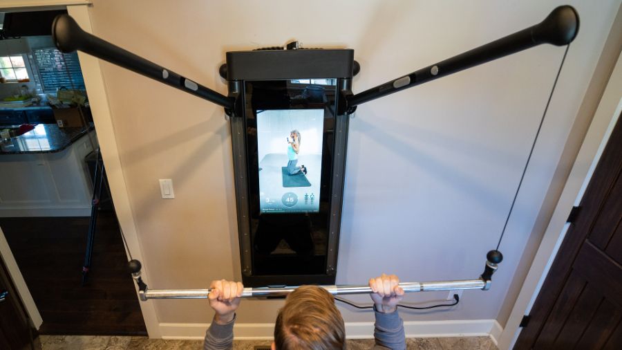 man using best functional trainer Tonal Smart Home Gym at home