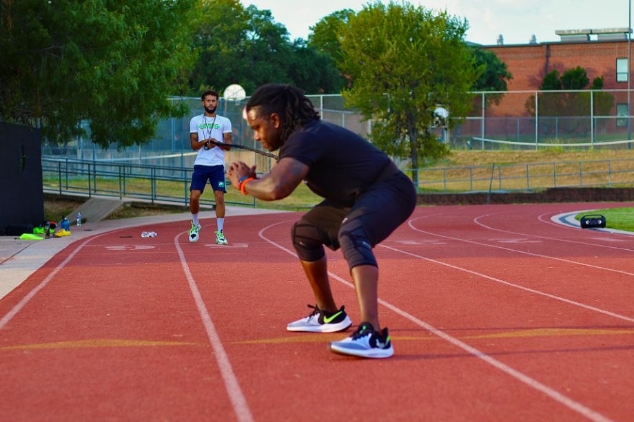 Man doing conditioning exercises on a track field