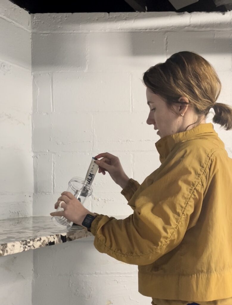 An image of a woman mixing Transparent Labs BULK pre-workout in a shaker