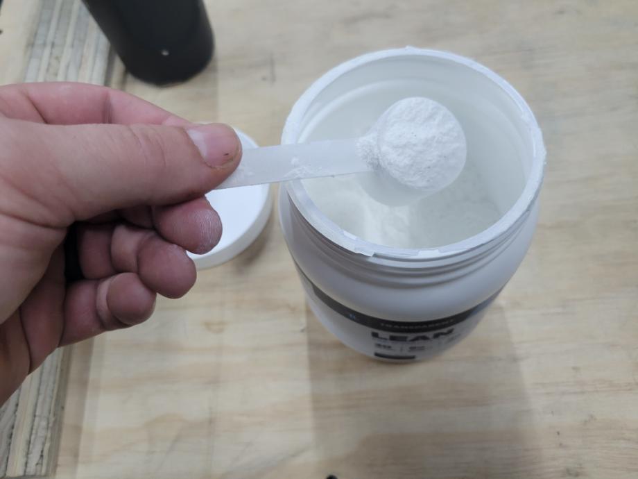 Looking down on a scoop of Transparent Labs Pre-Workout as it's being lifted from the container.