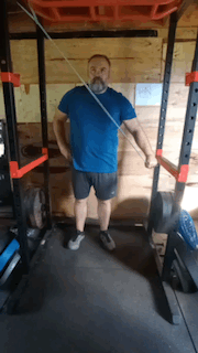 Man doing banded triceps extension in the squat rack