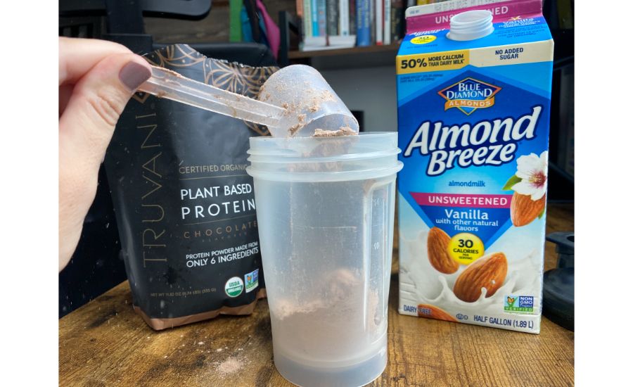 Person adding Truvani Plant Protein to shaker bottle