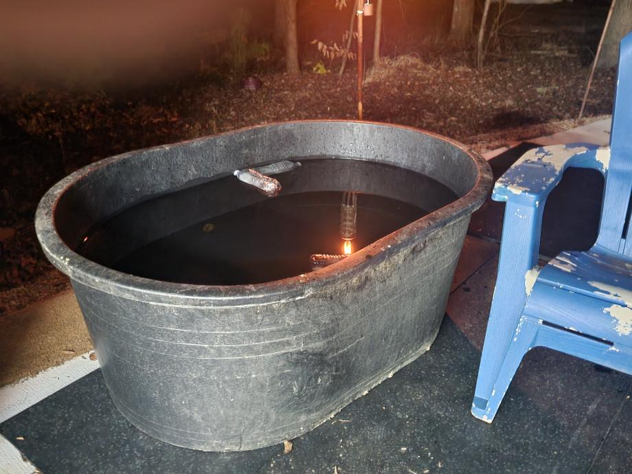 Ice water filled Tuff Stuff Stock Tank next to a blue patio chair