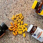 several bottles of turmeric supplements with pills showing the variation