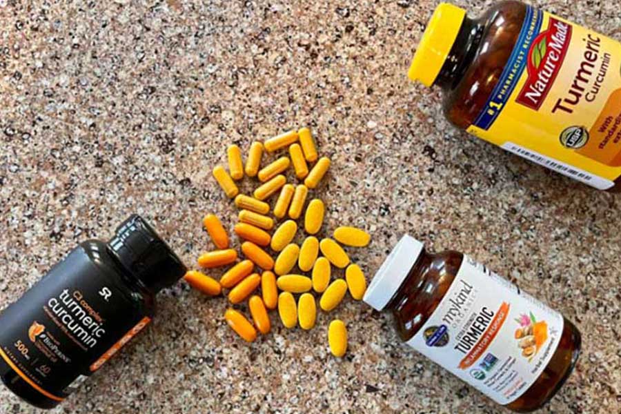 several bottles of turmeric supplements with pills showing the variation