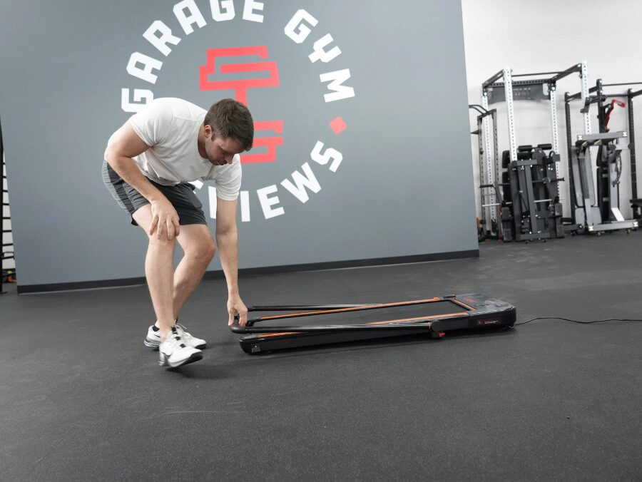 Nathan folding down the handlbar of the UREVO treadmill