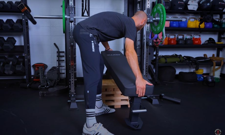 man using pulling block to turn flat bench into incline bench