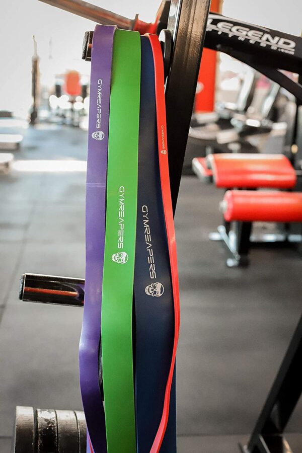 Gymreapers Resistance Bands in various sizes and colors hanging from piece of workout equipment.