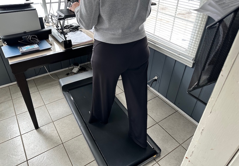 An image of a woman walking on the WalkingPad in her office for the WalkingPad review