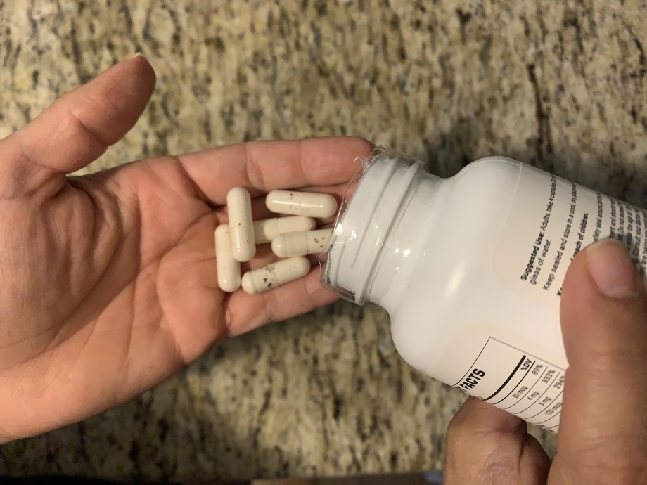 someone pouring weight loss pills into their hand