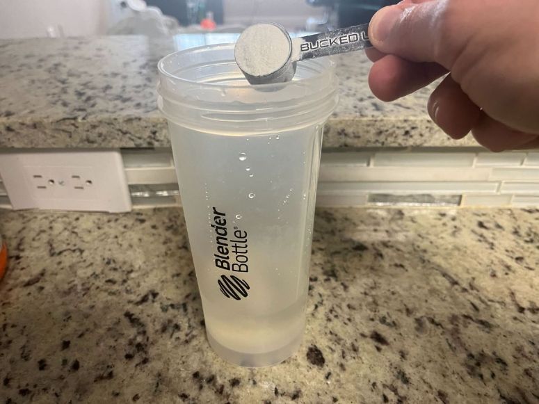 Woke AF pre-workout review pouring scoop