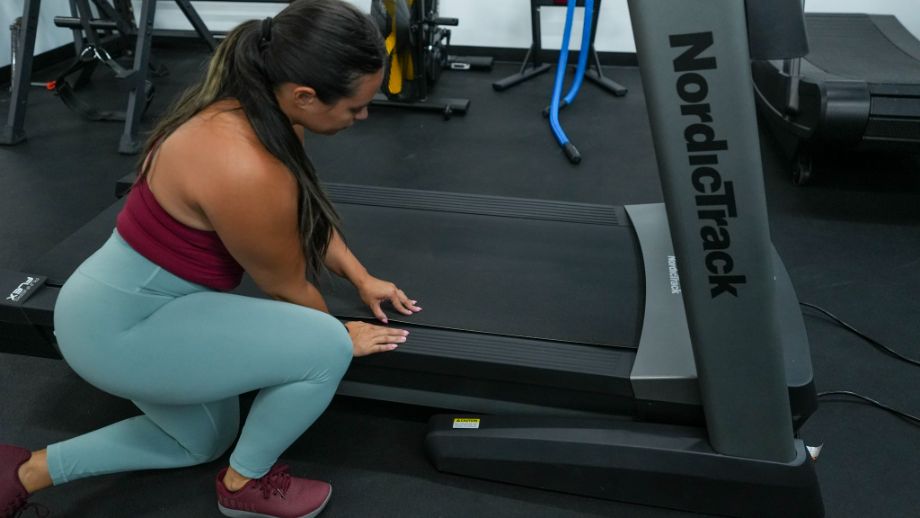 woman assessing nordictrack treadmill belt
