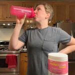 Woman drinks a shaker cup of AminoLean Pre-Workout