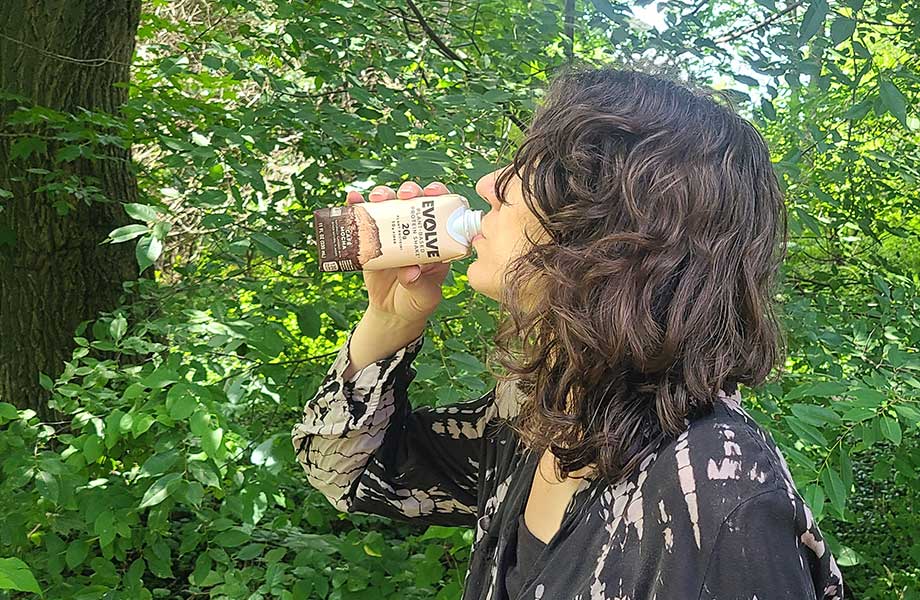 Woman drinking an Evolve plant-based protein shake