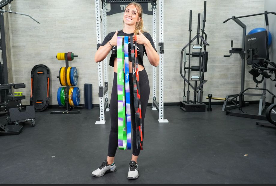 Woman holding living.fit resistance bands
