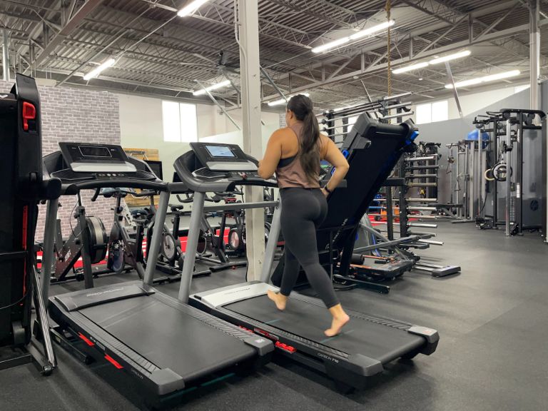 Woman running barefoot on a treadmill
