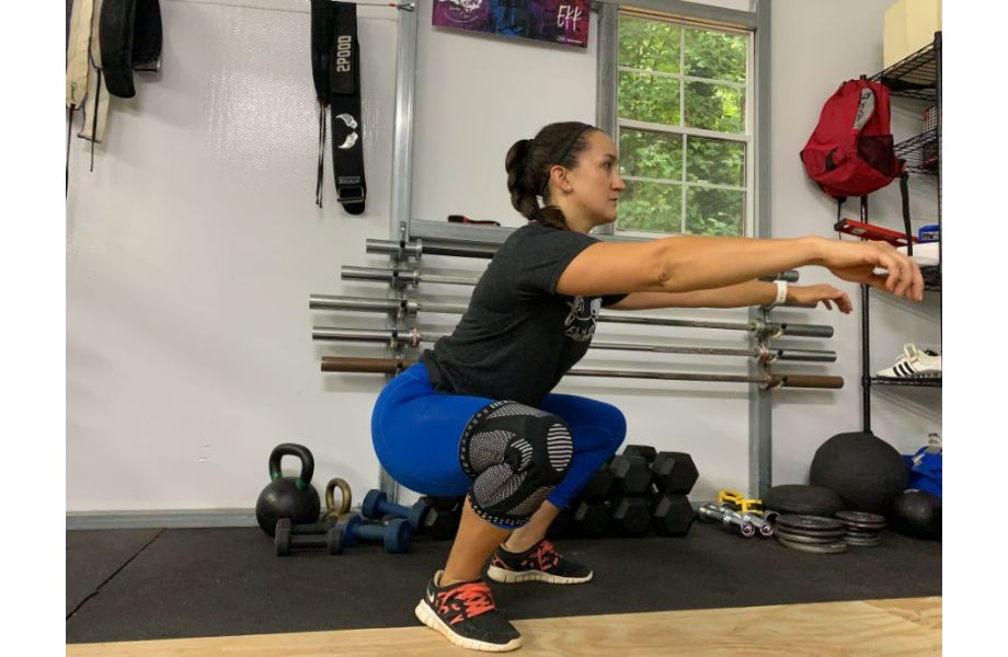 woman squatting with neenca knee sleeves