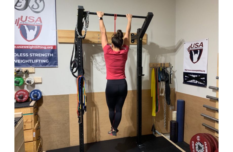 woman hanging on pull up bar