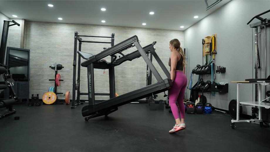 Woman moving Xebex ST-6000 treadmill using transport wheels