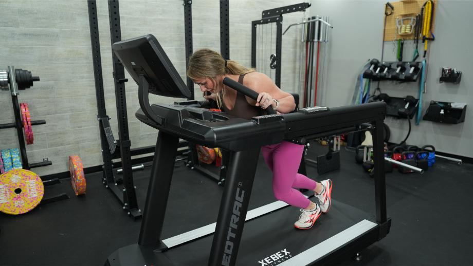 Woman using sled push function on Xebex ST-6000 treadmill